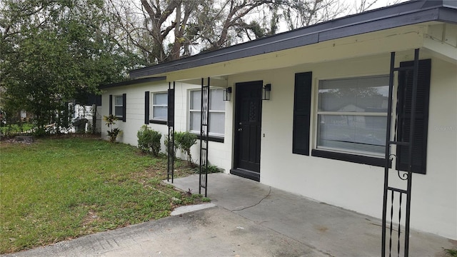 view of front of house featuring a front lawn and stucco siding