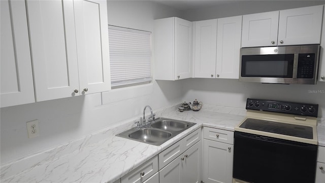 kitchen with white cabinets, stainless steel microwave, a sink, and electric range oven