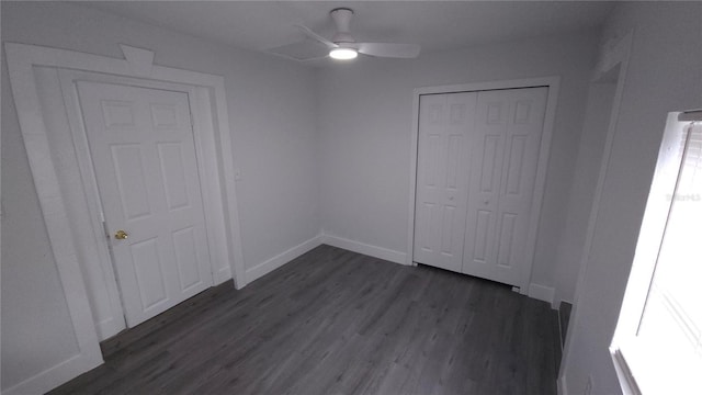 unfurnished bedroom featuring ceiling fan, dark wood-style flooring, a closet, and baseboards