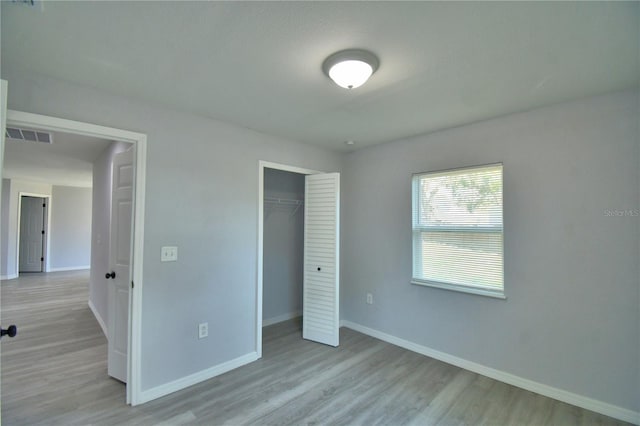 unfurnished bedroom featuring light hardwood / wood-style flooring and a closet