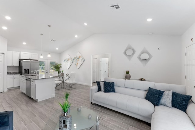 living room featuring sink and vaulted ceiling