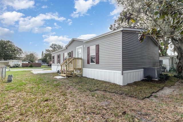 view of side of property featuring a lawn and central air condition unit