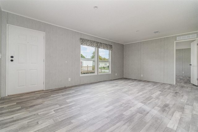 spare room featuring light hardwood / wood-style flooring and ornamental molding