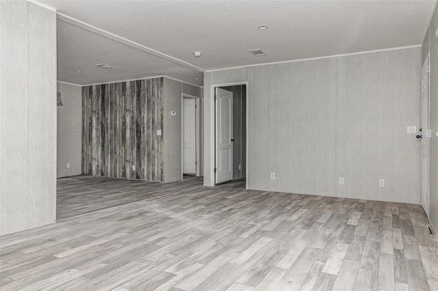 unfurnished room featuring ornamental molding and light hardwood / wood-style flooring