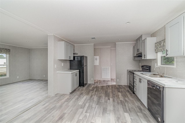 kitchen with sink, a wealth of natural light, black appliances, light hardwood / wood-style floors, and decorative backsplash