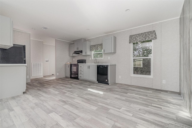 kitchen with gray cabinetry, black appliances, and light wood-type flooring