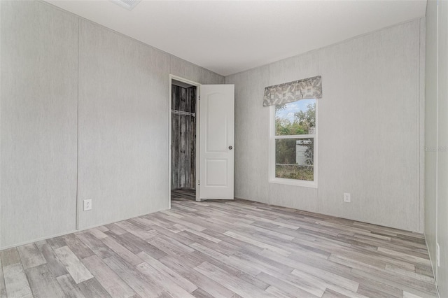 unfurnished bedroom featuring light hardwood / wood-style floors and a closet