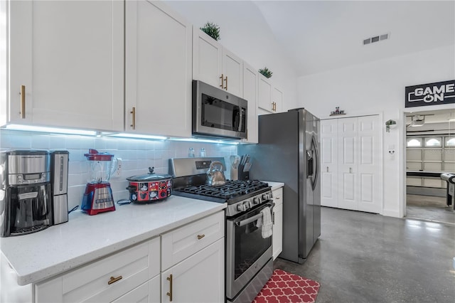 kitchen with white cabinetry, backsplash, light stone countertops, and appliances with stainless steel finishes