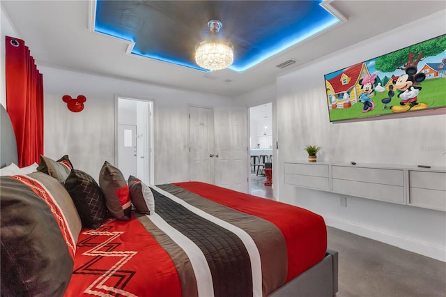 bedroom featuring an inviting chandelier, a tray ceiling, and concrete flooring