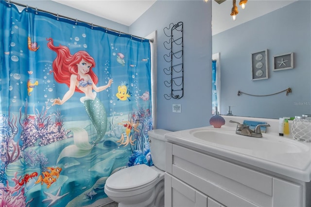 bathroom featuring a shower with curtain, vanity, and toilet