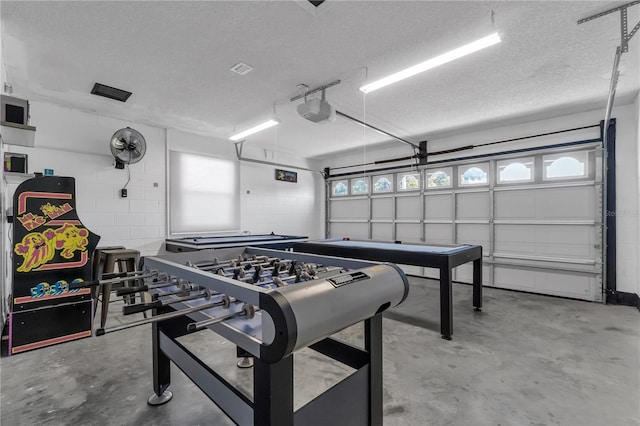 playroom featuring concrete floors and a textured ceiling