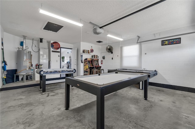 playroom with gas water heater, concrete floors, and a textured ceiling