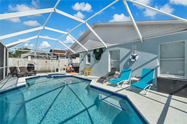 view of pool with glass enclosure and a patio area