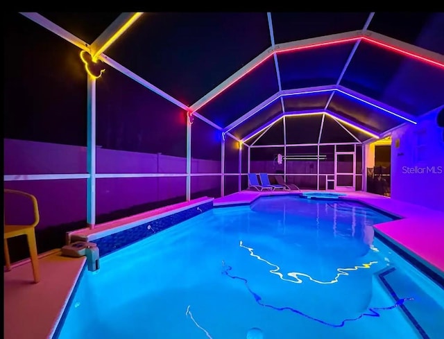 view of pool with a patio, a hot tub, and glass enclosure