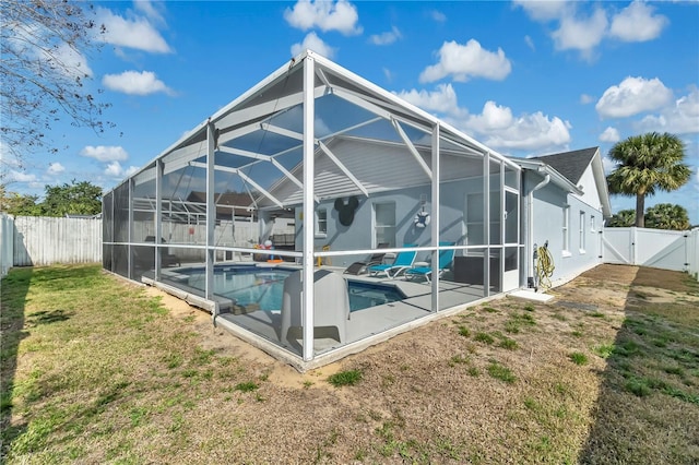 back of house with a patio, a fenced in pool, glass enclosure, and a lawn