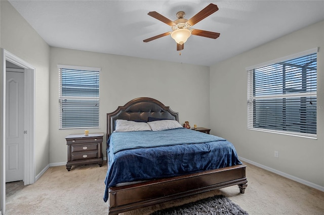 bedroom with multiple windows, light colored carpet, and ceiling fan