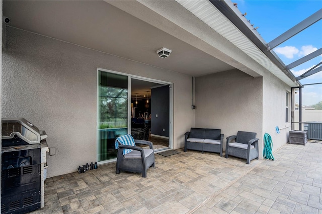 view of patio / terrace featuring an outdoor hangout area and glass enclosure