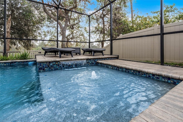 view of swimming pool with a patio, pool water feature, and glass enclosure