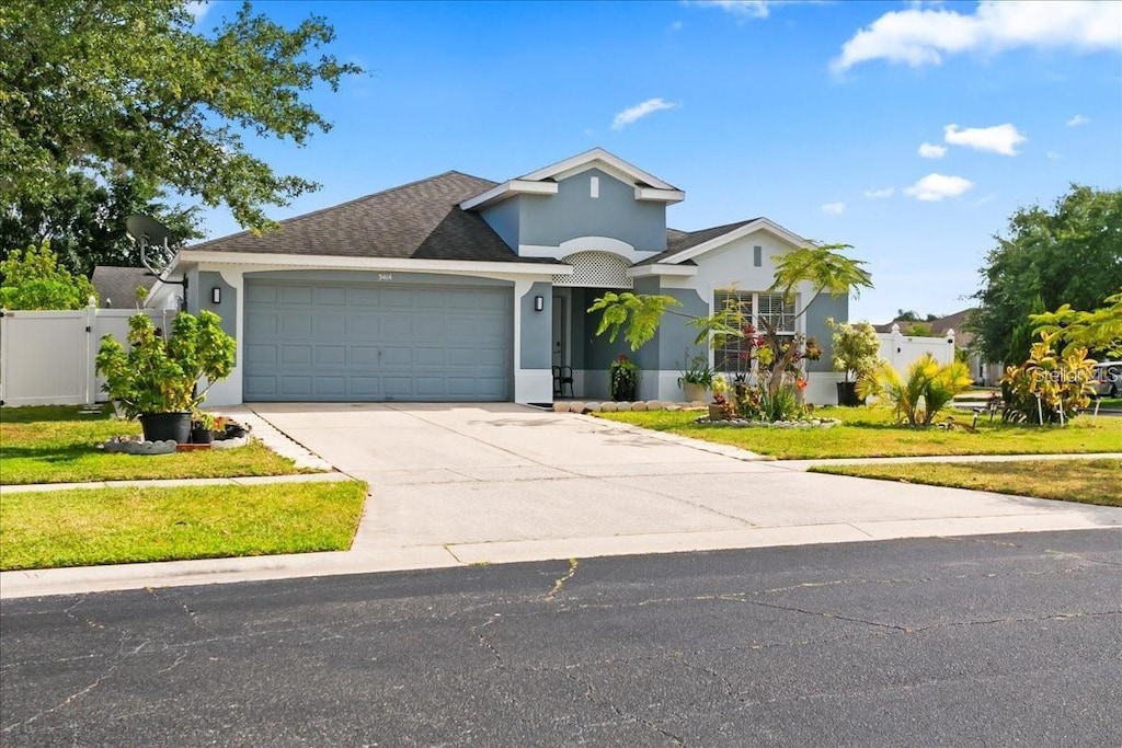 front of property with a garage and a front lawn