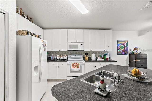 kitchen featuring white cabinetry, white appliances, and tasteful backsplash