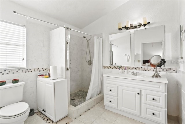 bathroom with tile walls, a shower with shower curtain, vanity, tile patterned floors, and toilet