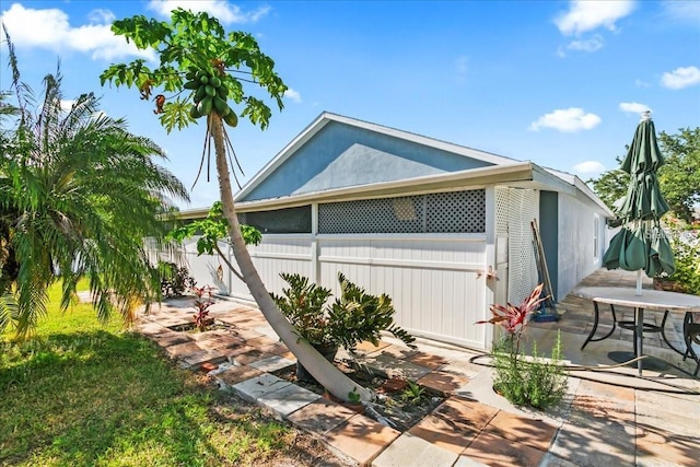 view of property exterior with a patio and a yard