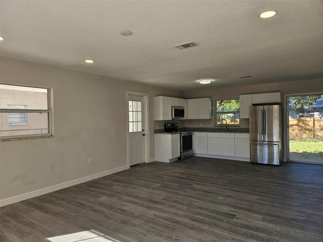 kitchen featuring dark wood-type flooring, sink, white cabinetry, a textured ceiling, and appliances with stainless steel finishes