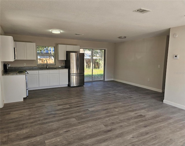 kitchen featuring sink, appliances with stainless steel finishes, dark hardwood / wood-style floors, a textured ceiling, and white cabinets