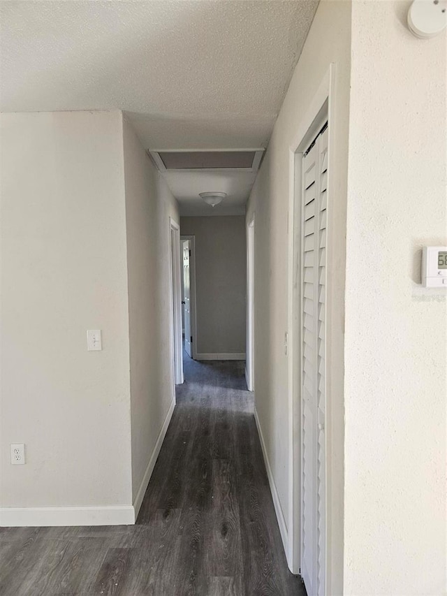 hall with dark hardwood / wood-style floors and a textured ceiling