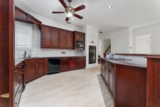 kitchen featuring sink, light hardwood / wood-style flooring, light stone countertops, decorative backsplash, and black appliances