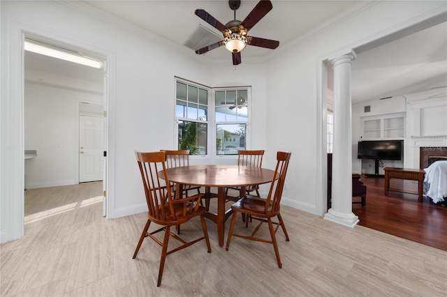 dining room with crown molding, ceiling fan, light hardwood / wood-style flooring, and ornate columns