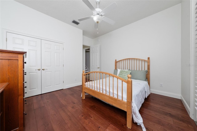 bedroom with a closet, a textured ceiling, dark hardwood / wood-style floors, and ceiling fan