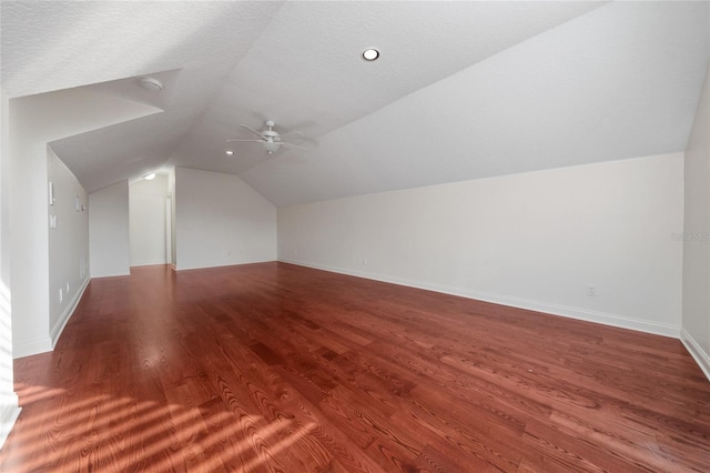 additional living space with lofted ceiling, hardwood / wood-style floors, a textured ceiling, and ceiling fan