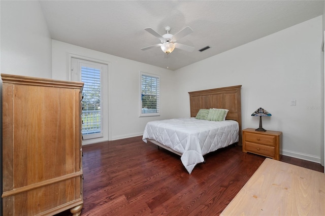 bedroom featuring a textured ceiling, dark wood-type flooring, and ceiling fan