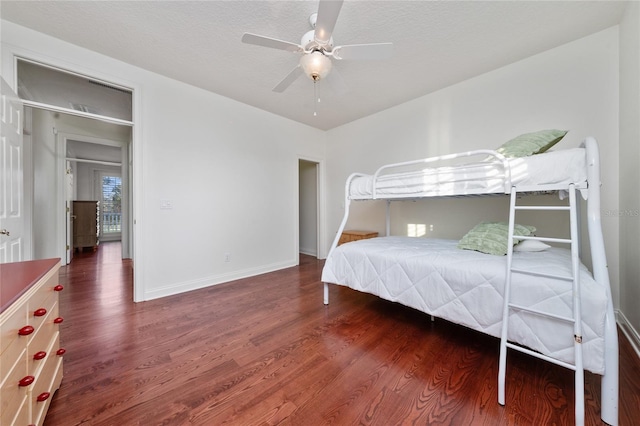 unfurnished bedroom with dark wood-type flooring, ceiling fan, and a textured ceiling