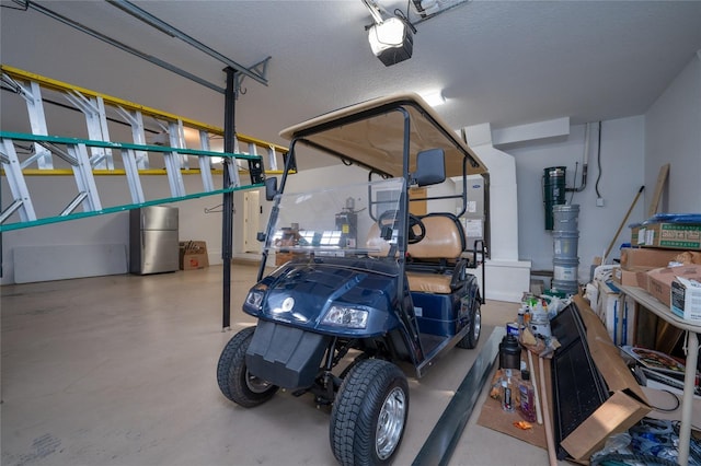 garage with a garage door opener and stainless steel refrigerator