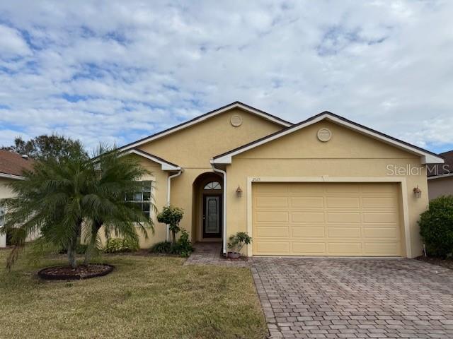 ranch-style house with a garage and a front lawn