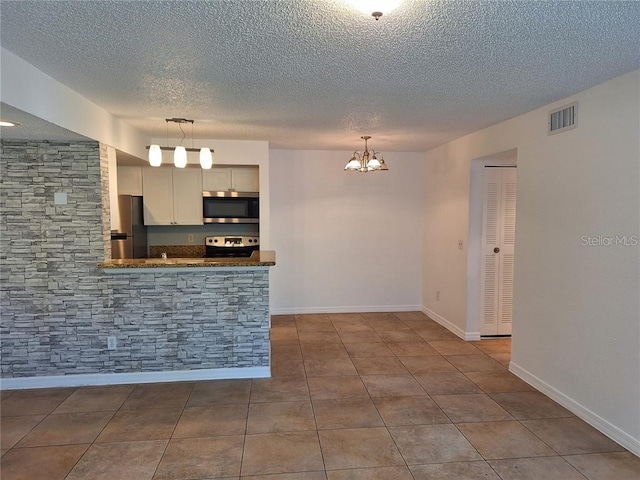 kitchen with white cabinetry, hanging light fixtures, kitchen peninsula, and appliances with stainless steel finishes