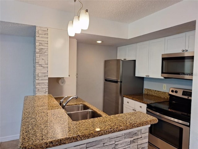 kitchen with white cabinetry, sink, kitchen peninsula, stainless steel appliances, and a textured ceiling