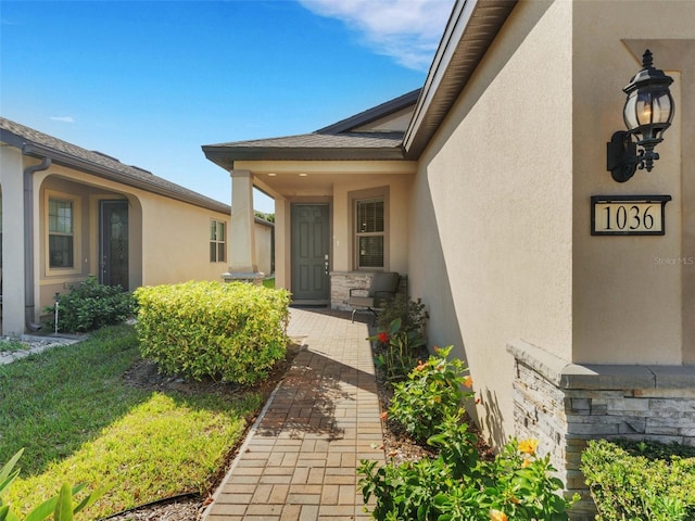 doorway to property featuring stucco siding