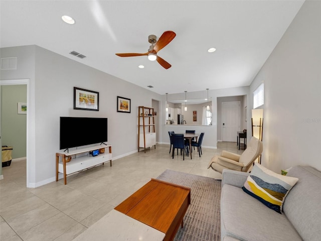 living area with baseboards, visible vents, and recessed lighting