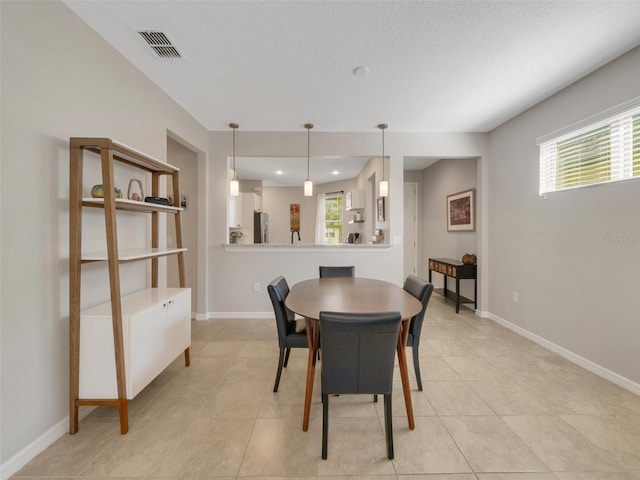 dining area featuring light tile patterned flooring, visible vents, and baseboards