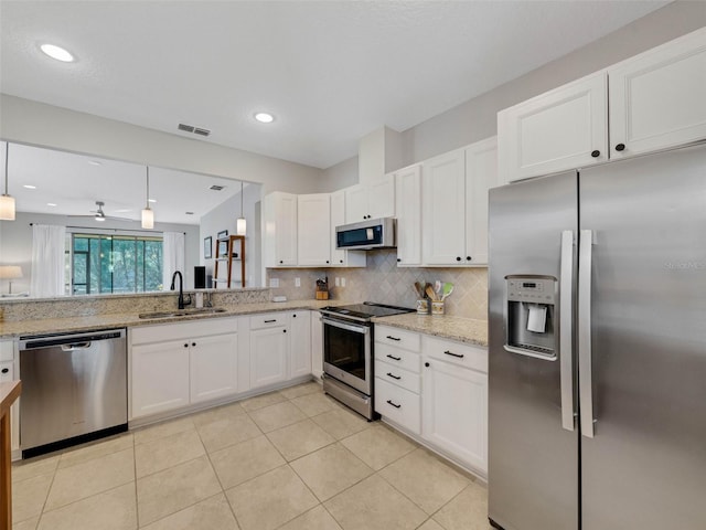 kitchen featuring visible vents, decorative backsplash, appliances with stainless steel finishes, white cabinetry, and a sink