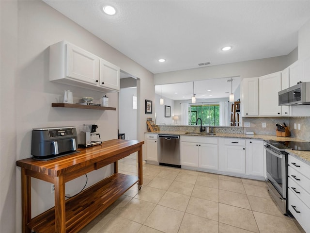 kitchen with appliances with stainless steel finishes, white cabinetry, and a sink