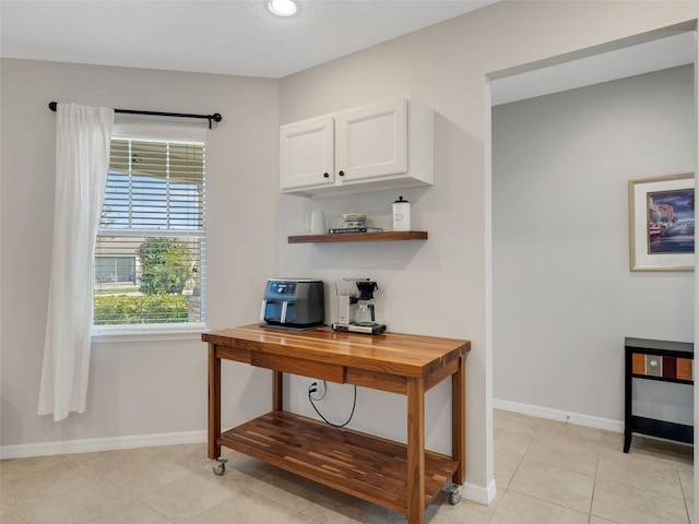 home office featuring light tile patterned floors and baseboards