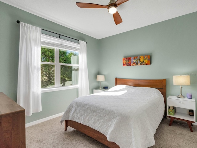 carpeted bedroom featuring ceiling fan and baseboards