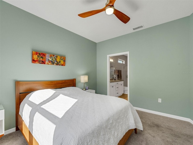 bedroom featuring baseboards, visible vents, a ceiling fan, ensuite bath, and carpet flooring