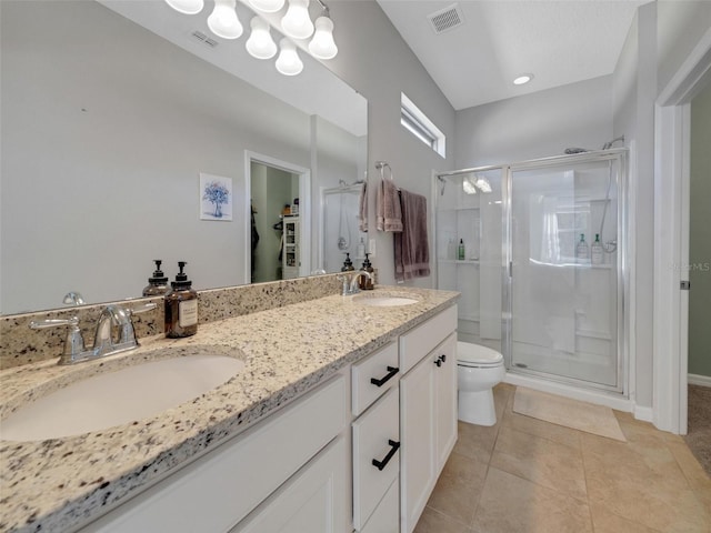 bathroom featuring toilet, a shower stall, visible vents, and a sink