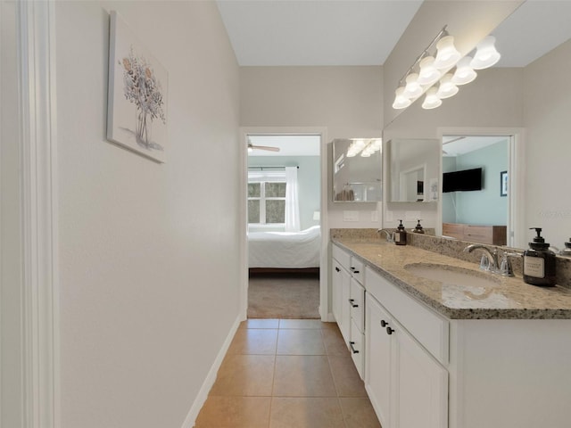 full bathroom featuring double vanity, a sink, ensuite bath, baseboards, and tile patterned floors