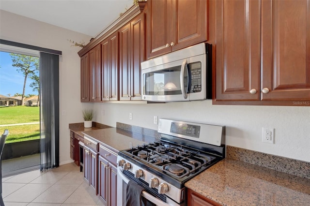 kitchen with light tile patterned floors, stainless steel appliances, and stone counters